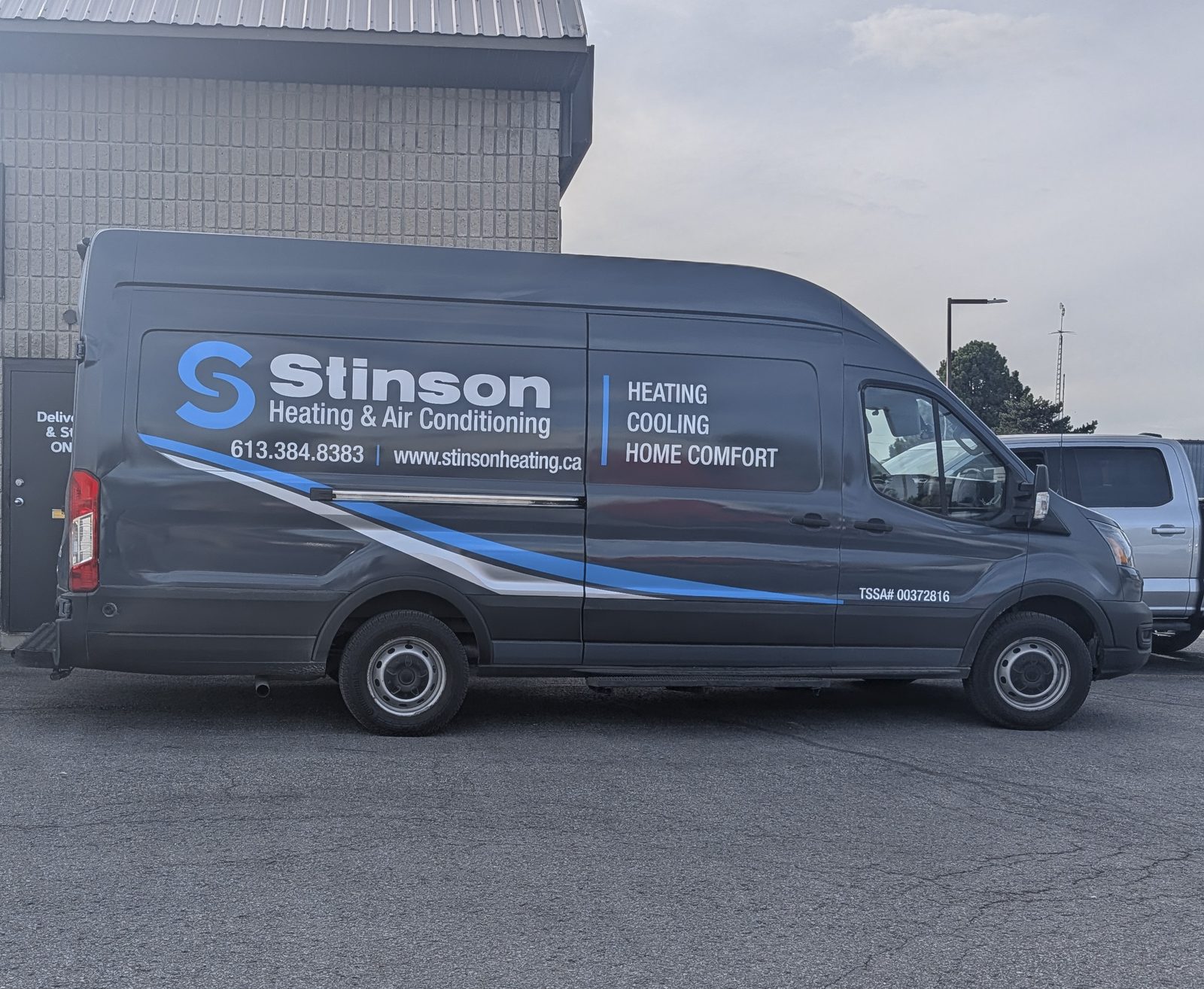 T.H. Stinson's dark wrapped service van parked outdoors