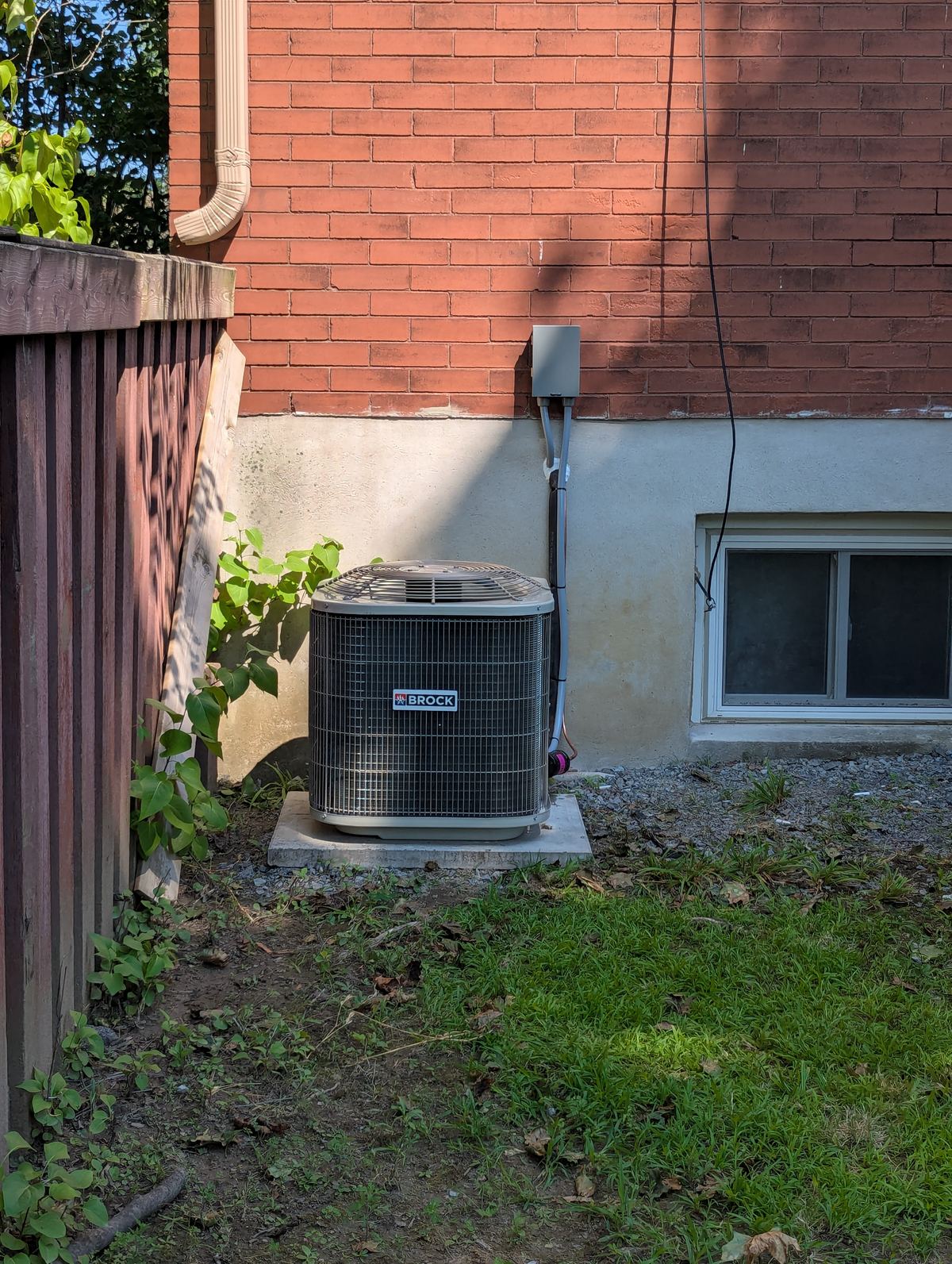 Brock air conditioner installed beside a brick home
