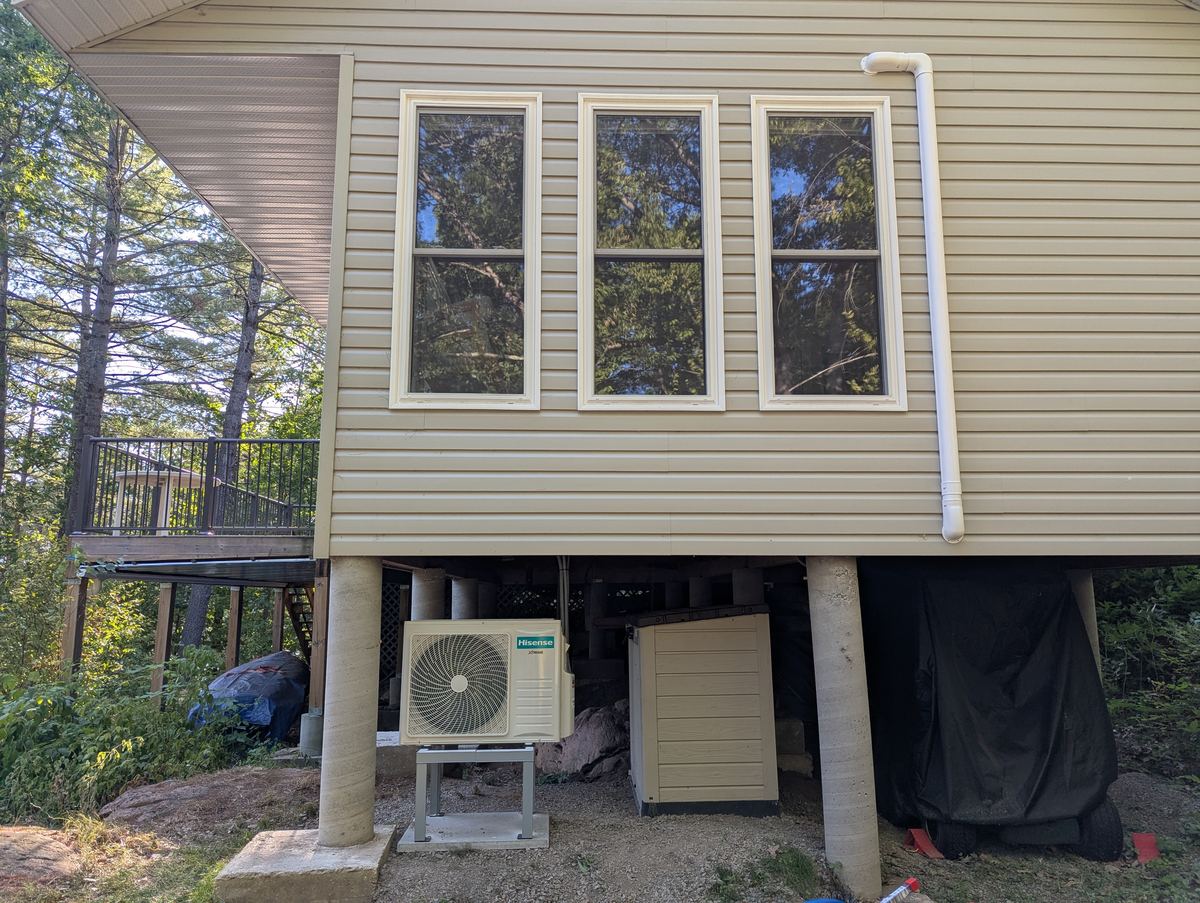 Heat pump equipment beneath a raised cottage